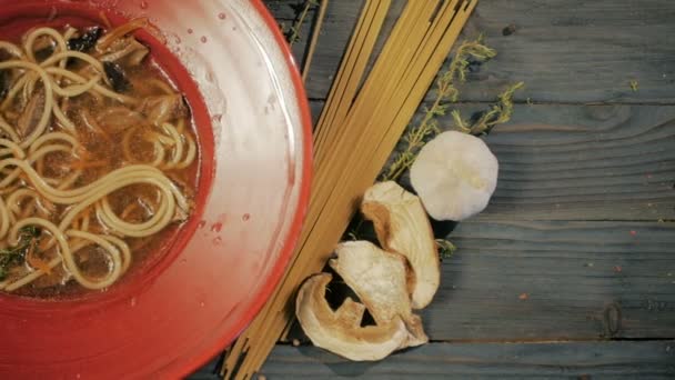 Svampsoppa med spaghetti pasta. Ovanifrån. På en svart trä bakgrund. Kopiera utrymme. — Stockvideo