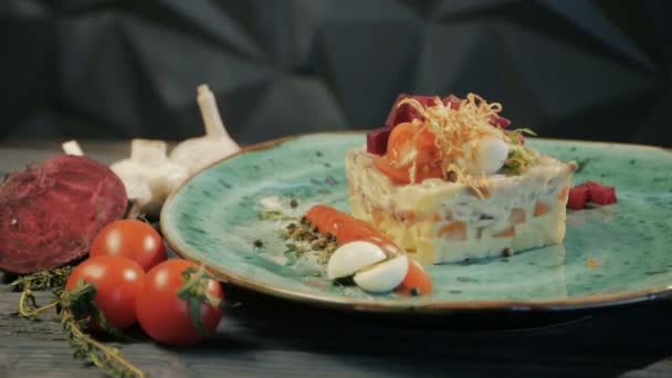 Cocina tradicional rusa. Shub ensalada con arenque. Dolly disparó. Sobre un fondo de madera negro. Copiar espacio . — Vídeos de Stock