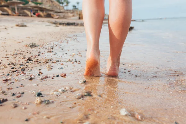 Schöne Mädchen Beine Spaziergänge auf dem Sand und Meerwasser am Strand — Stockfoto