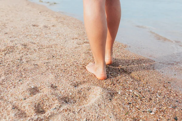 Frau geht am Strand spazieren und hinterlässt Spuren im Sand — Stockfoto