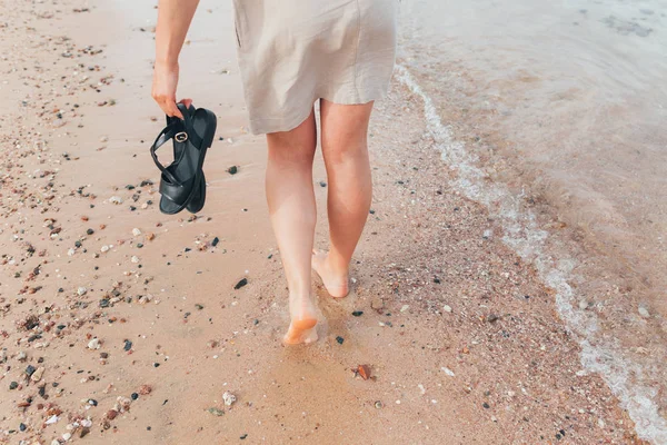 Frau geht am Strand spazieren und hinterlässt Spuren im Sand — Stockfoto