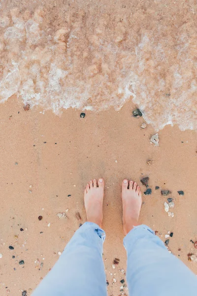 Frau gebräunte Beine am Sandstrand — Stockfoto