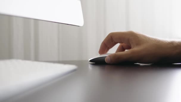 Чоловік працює в офісі і клацає на білій комп'ютерній миші — стокове відео