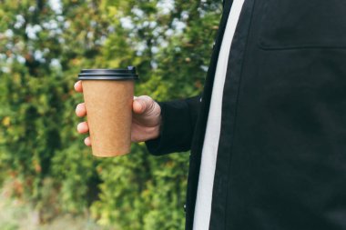 Çekici bir adam kafenin dışında kahve içip eğleniyor.