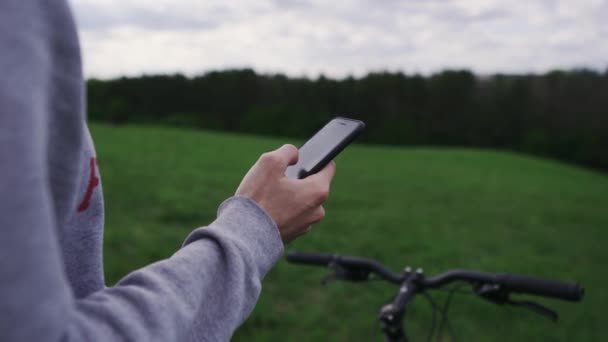 Ποδηλάτης χρησιμοποιεί GPS χάρτη παρακολούθησης στο τηλέφωνο στα βουνά στη φύση — Αρχείο Βίντεο