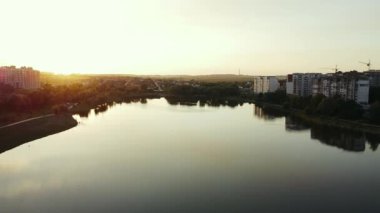 Gün batımında şehirdeki bir yerleşim yerindeki göl manzarası.