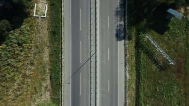 Otobanda yeni bir yolda üzerinde işaretler olan araba ve kamyonların üst görüntüsü.