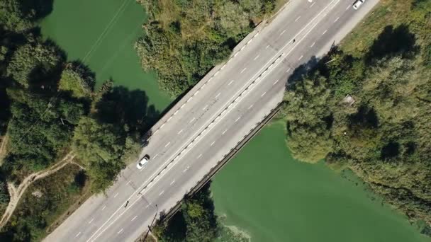 Flygfoto av bilar och lastbilar passerar över bron nära floden och skogen — Stockvideo