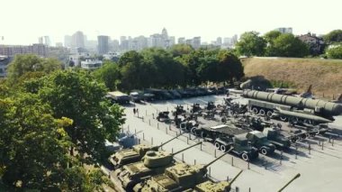 İnsanlar askeri teçhizat, tank, top, uçak müzesinde dolaşıyorlar.