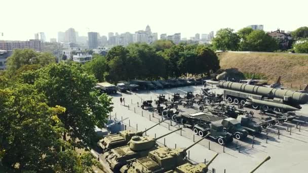 Ludzie chodzą po muzeum sprzętu wojskowego, czołgów, armat, samolotów — Wideo stockowe