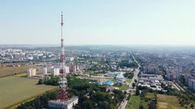 Güneşli bir günde büyük bir şehrin arka planına karşı TV kulesinin etrafında uçmak