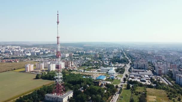 阳光灿烂的一天，在一座大城市的背景下，绕着电视塔飞来飞去 — 图库视频影像