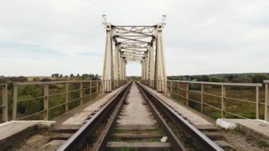 Tren hareketi. Demiryolu raylarından demir köprünün üzerinden uçuyor.