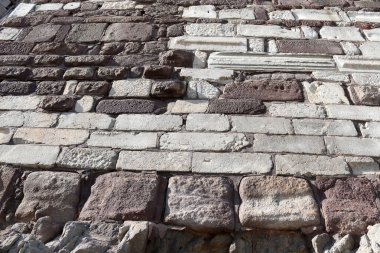 Close-up of rustic brown stone block wall with mortar seams. High-resolution masonry background for architecture, patterns, restoration, archaeology, construction themes and design mockups.