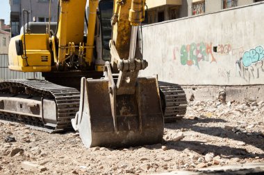 03 September 2025, Ankara, Turkey  Yellow crawler excavator on rubble at an urban demolition site beside residential buildings; editorial use for news, construction, infrastructure, redevelopment