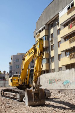 03 September 2025, Ankara, Turkey  Yellow crawler excavator on rubble at an urban demolition site beside residential buildings; editorial use for news, construction, infrastructure, redevelopment