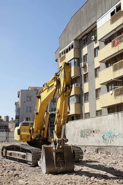03 September 2025, Ankara, Turkey  Yellow crawler excavator on rubble at an urban demolition site beside residential buildings; editorial use for news, construction, infrastructure, redevelopment