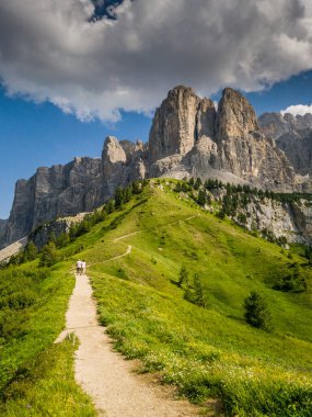 İtalya 'nın Passo Giau kentindeki Dolomitler boyunca uzanan manzaralı bir yaz yolu, yemyeşil ve yüksek zirvelerle çevrili, görkemli dağların nefes kesici manzaralarını sunuyor.