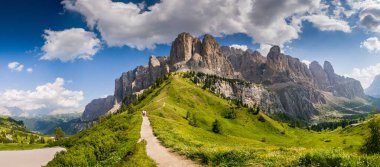 İtalya 'nın Passo Giau kentindeki Dolomitler boyunca uzanan manzaralı bir yaz yolu, yemyeşil ve yüksek zirvelerle çevrili, görkemli dağların nefes kesici manzaralarını sunuyor.