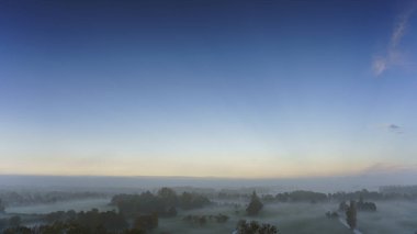 Hollanda 'nın kırsal kesimindeki yemyeşil tarlalara bakan nefes kesici balkon manzarası Amsterdam, Hollanda yakınlarında sisli bir yaz gündoğumu sırasında