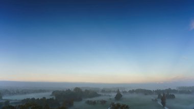 Hollanda 'nın kırsal kesimindeki yemyeşil tarlalara bakan nefes kesici balkon manzarası Amsterdam, Hollanda yakınlarında sisli bir yaz gündoğumu sırasında