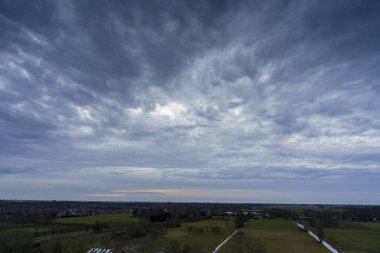 Hollanda 'nın kırsal kesimindeki yemyeşil tarlalara bakan nefes kesici balkon manzarası Amsterdam, Hollanda yakınlarındaki fırtınalı yaz günbatımında