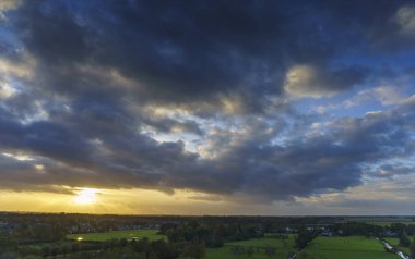 Hollanda 'nın kırsal kesimindeki yemyeşil tarlalara bakan nefes kesici balkon manzarası Amsterdam, Hollanda yakınlarındaki fırtınalı yaz günbatımında