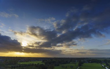 Hollanda 'nın kırsal kesimindeki yemyeşil tarlalara bakan nefes kesici balkon manzarası Amsterdam, Hollanda yakınlarındaki fırtınalı yaz günbatımında