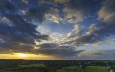 Hollanda 'nın kırsal kesimindeki yemyeşil tarlalara bakan nefes kesici balkon manzarası Amsterdam, Hollanda yakınlarındaki fırtınalı yaz günbatımında