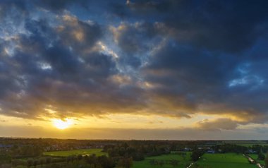 Hollanda 'nın kırsal kesimindeki yemyeşil tarlalara bakan nefes kesici balkon manzarası Amsterdam, Hollanda yakınlarındaki fırtınalı yaz günbatımında