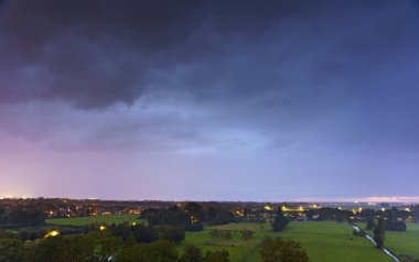 Hollanda 'nın kırsal kesimindeki yemyeşil tarlalara bakan nefes kesici balkon manzarası Amsterdam, Hollanda yakınlarındaki fırtınalı yaz günbatımında