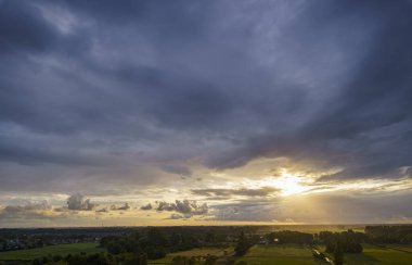 Hollanda 'nın kırsal kesimindeki yemyeşil tarlalara bakan nefes kesici balkon manzarası Amsterdam, Hollanda yakınlarındaki fırtınalı yaz günbatımında