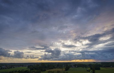 Hollanda 'nın kırsal kesimindeki yemyeşil tarlalara bakan nefes kesici balkon manzarası Amsterdam, Hollanda yakınlarındaki fırtınalı yaz günbatımında