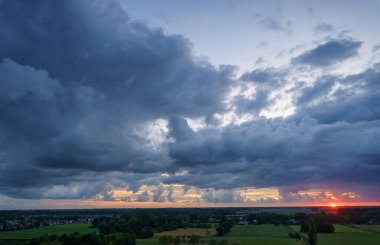 Hollanda 'nın kırsal kesimindeki yemyeşil tarlalara bakan nefes kesici balkon manzarası Amsterdam, Hollanda yakınlarındaki fırtınalı yaz günbatımında