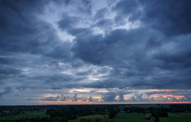 Hollanda 'nın kırsal kesimindeki yemyeşil tarlalara bakan nefes kesici balkon manzarası Amsterdam, Hollanda yakınlarındaki fırtınalı yaz günbatımında