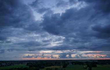 Hollanda 'nın kırsal kesimindeki yemyeşil tarlalara bakan nefes kesici balkon manzarası Amsterdam, Hollanda yakınlarındaki fırtınalı yaz günbatımında