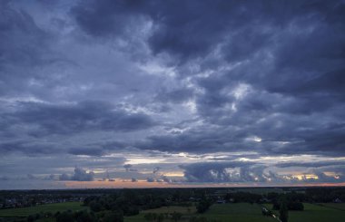 Hollanda 'nın kırsal kesimindeki yemyeşil tarlalara bakan nefes kesici balkon manzarası Amsterdam, Hollanda yakınlarındaki fırtınalı yaz günbatımında