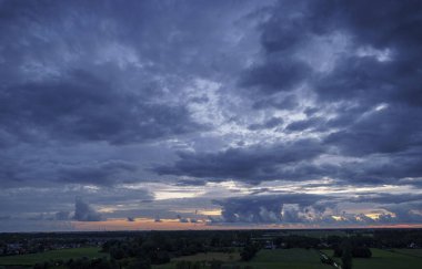 Hollanda 'nın kırsal kesimindeki yemyeşil tarlalara bakan nefes kesici balkon manzarası Amsterdam, Hollanda yakınlarındaki fırtınalı yaz günbatımında
