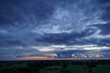 Hollanda 'nın kırsal kesimindeki yemyeşil tarlalara bakan nefes kesici balkon manzarası Amsterdam, Hollanda yakınlarındaki fırtınalı yaz günbatımında