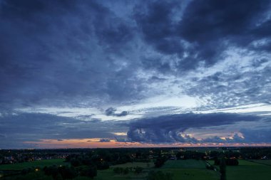 Hollanda 'nın kırsal kesimindeki yemyeşil tarlalara bakan nefes kesici balkon manzarası Amsterdam, Hollanda yakınlarındaki fırtınalı yaz günbatımında