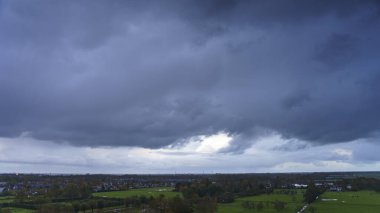 Hollanda 'nın kırsal kesimindeki yemyeşil tarlalara bakan nefes kesici balkon manzarası Amsterdam, Hollanda yakınlarındaki fırtınalı yaz günbatımında