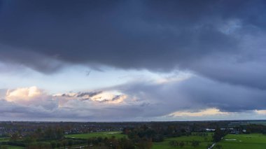 Hollanda 'nın kırsal kesimindeki yemyeşil tarlalara bakan nefes kesici balkon manzarası Amsterdam, Hollanda yakınlarındaki fırtınalı yaz günbatımında