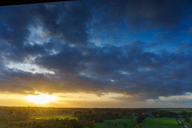 Hollanda 'nın kırsal kesimindeki yemyeşil tarlalara bakan nefes kesici balkon manzarası Amsterdam, Hollanda yakınlarındaki fırtınalı yaz günbatımında