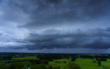 Hollanda 'nın kırsal kesimindeki yemyeşil tarlalara bakan nefes kesici balkon manzarası Amsterdam, Hollanda yakınlarındaki fırtınalı yaz günbatımında