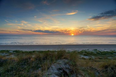 Petten, Hollanda yakınlarındaki Kuzey Denizi üzerinde inanılmaz bir yaz günbatımı manzarası.