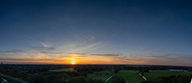 Purmerend 'in şehir siluetine bakan nefes kesici bir balkon manzarası. Hollanda, Amsterdam yakınlarında fırtınalı bir yaz günbatımının dramatik renkleriyle aydınlanıyor.