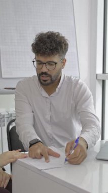 A focused professional is having an indepth discussion of important documents with a colleague in a modern office