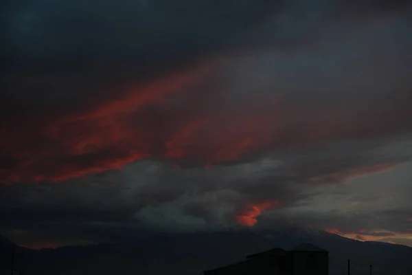 Arka planda dağ olan kırmızı bir gökyüzü.