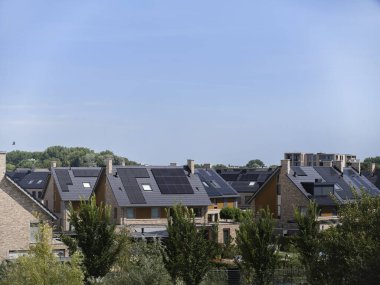 Detailed view of modern houses with extensive solar panel installations on residential rooftops