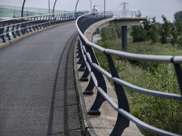 Modern bridge roadway showing curved design with protective railings and urban setting
